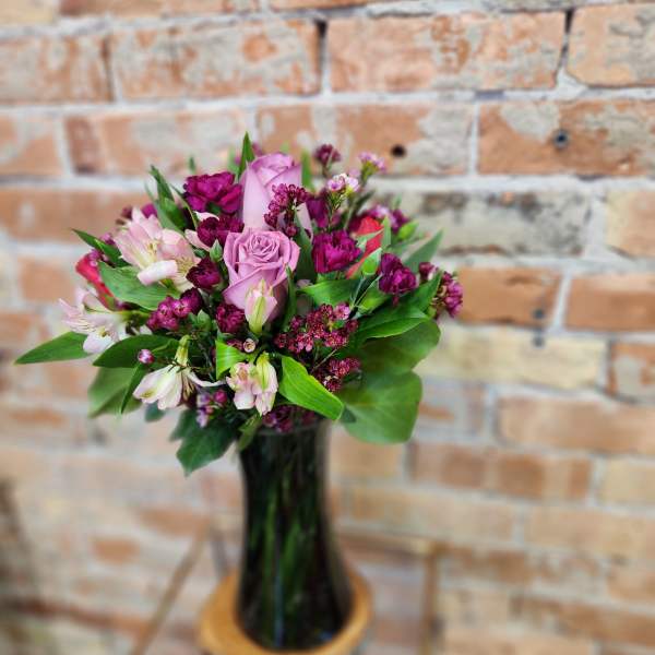 Pink and magenta bouquet in a tall glass vase