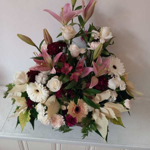 Pink lilies and white roses arranged with gerbera daisies in a low bouquet.