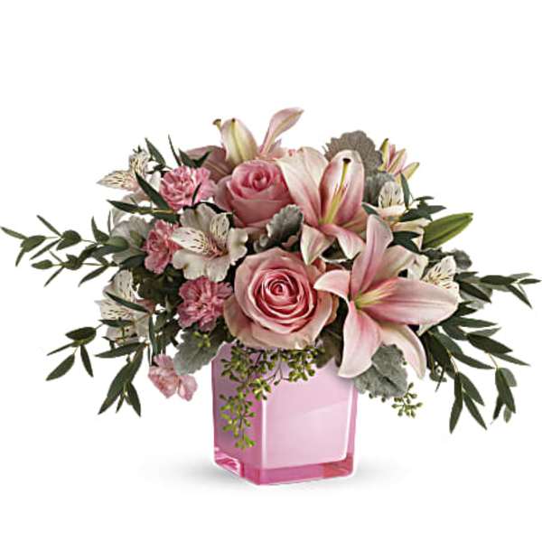 Pink roses and lilies arranged in a pink glass vase
