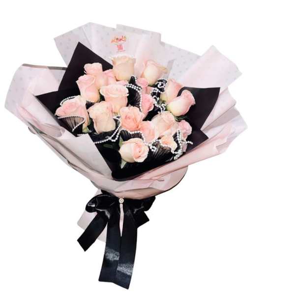 Bouquet of pale pink roses wrapped in pink and black paper