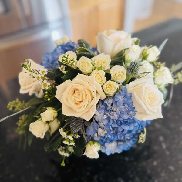 Bouquet of cream roses and blue hydrangeas