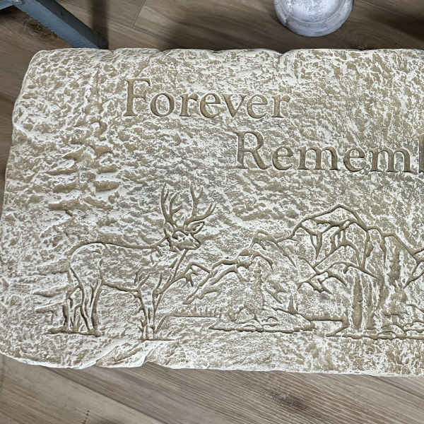 Rectangular memorial stone engraved with 'Forever Remembered' and a deer and mountain scene.