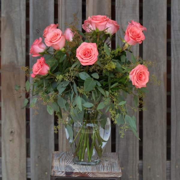 Pink roses arranged in a clear glass vase