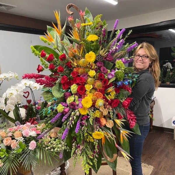 Large tropical bouquet with red roses, yellow daisies, and purple spikes