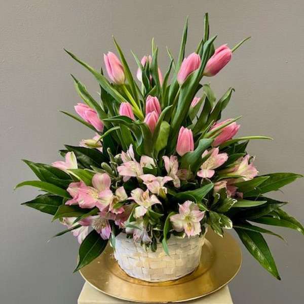 Pink tulips and pale pink alstroemeria in a white basket