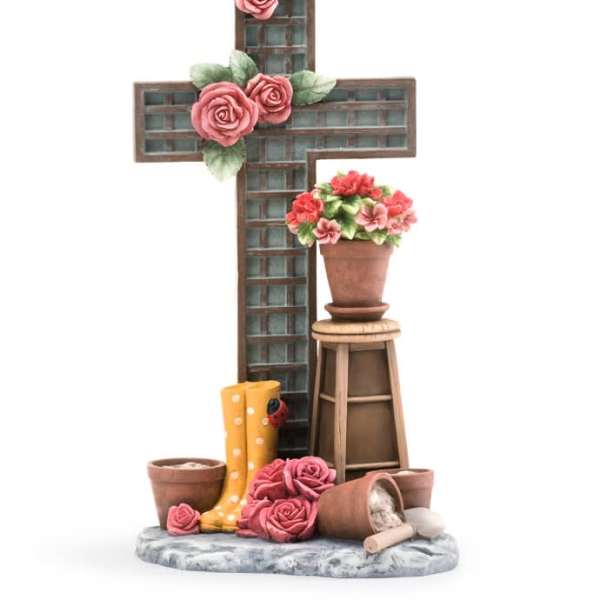 Decorative cross with pink roses and a potted flower arrangement