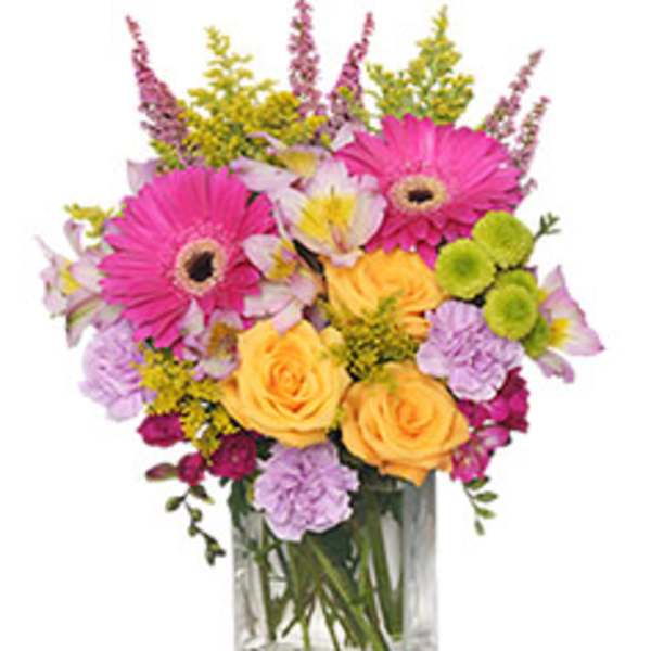 Mixed bouquet of pink gerberas and yellow roses in a glass vase