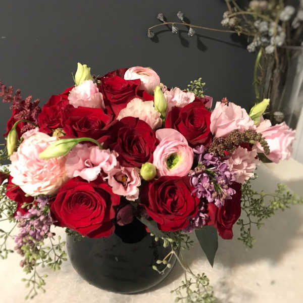 Bouquet of red and pink roses in a black vase