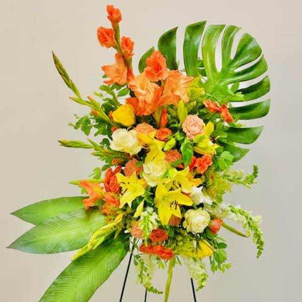Tall tropical floral spray with orange and yellow blooms on a stand