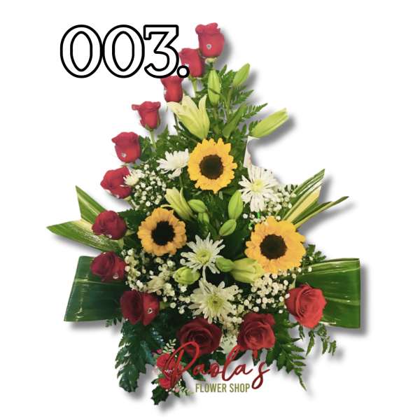Red roses with sunflowers and white lilies in a tall arrangement
