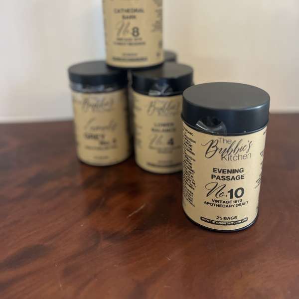 Set of four tan and black cylindrical canisters arranged on a wooden surface