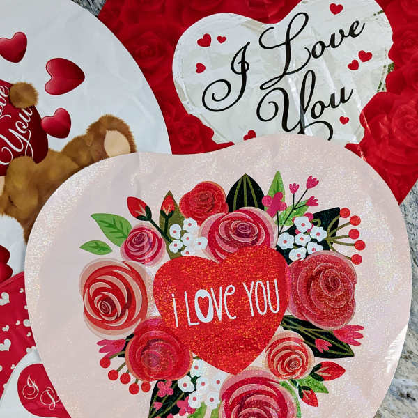 Heart-shaped Valentine balloons with roses and "I Love You" text