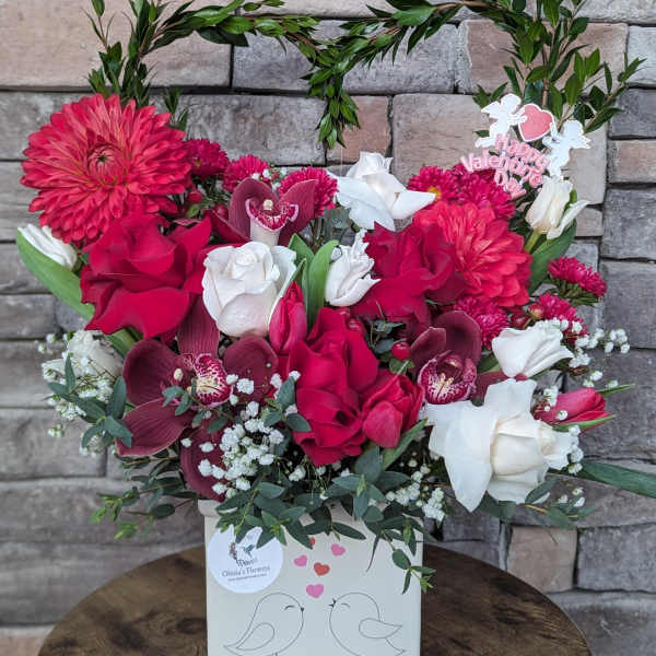 Pink and white floral arrangement in a white box with a Valentine topper