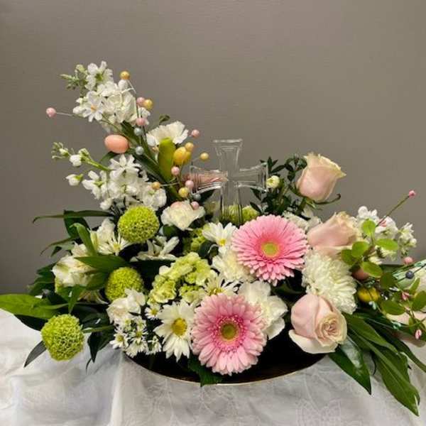 Pastel floral arrangement with a clear cross centerpiece