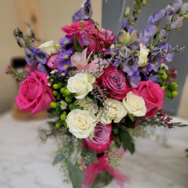 Bouquet of pink, white, and purple flowers in a glass vase