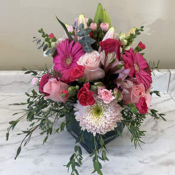 Pink and white mixed bouquet in a dark glass vase