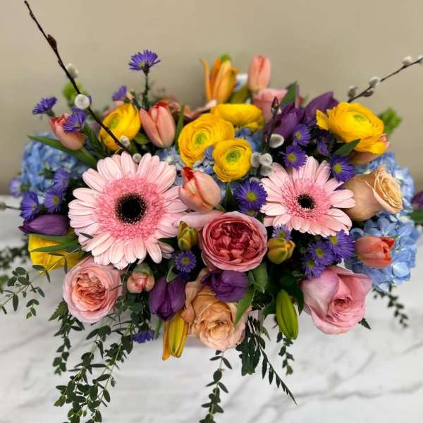 Colorful bouquet with pink gerbera daisies, roses, and yellow ranunculus