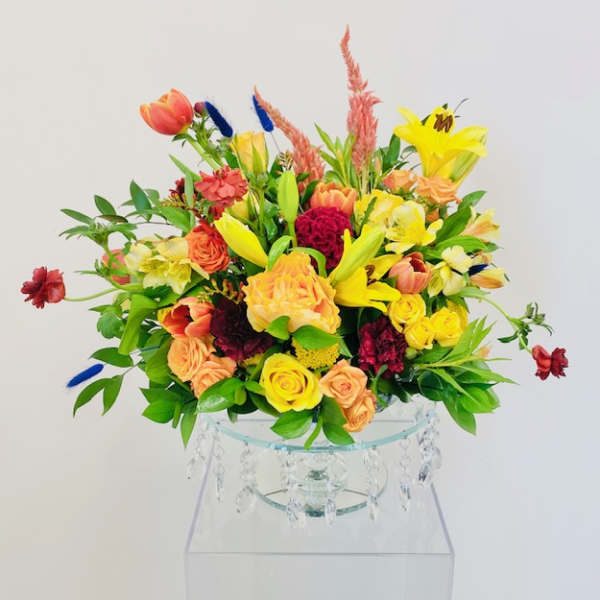 Colorful mixed bouquet in a clear glass vase with hanging crystals