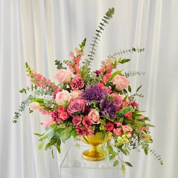 Pink and purple floral arrangement in a gold vase