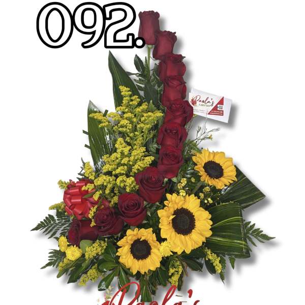 Red roses and yellow sunflowers in a tall floral arrangement