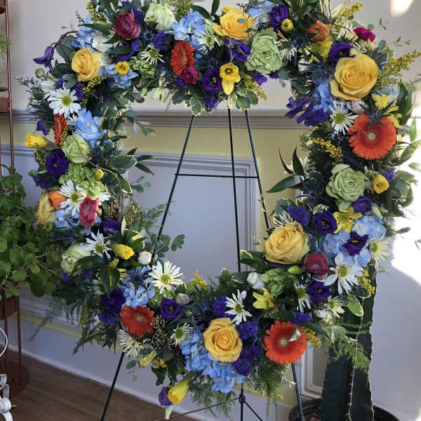 Large floral wreath on an easel with multicolored flowers