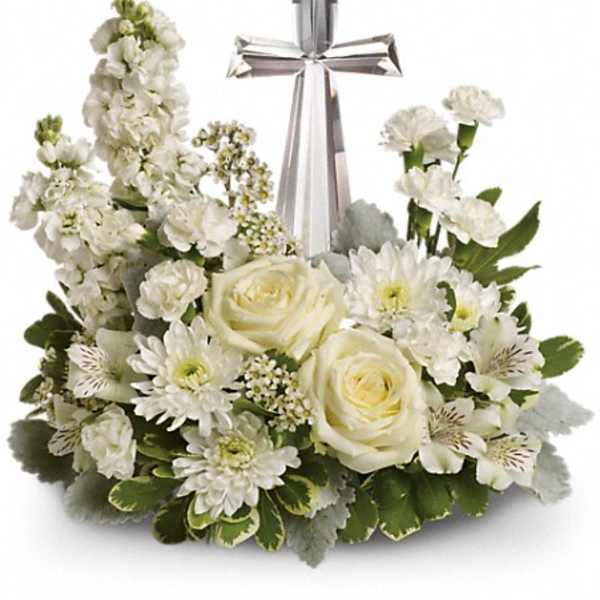 White floral arrangement with a silver cross centerpiece