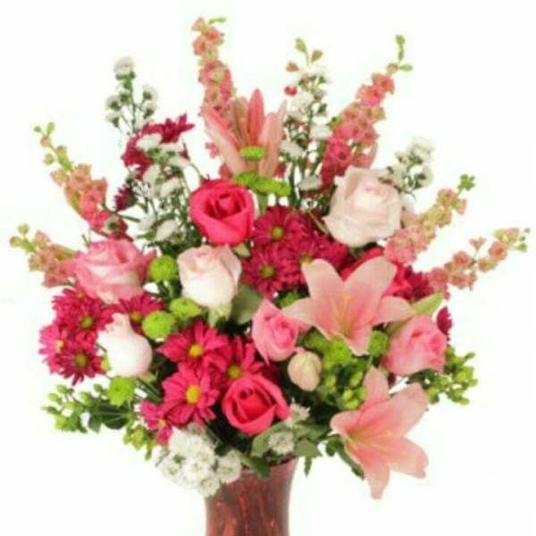 Pink and white mixed bouquet in a red glass vase