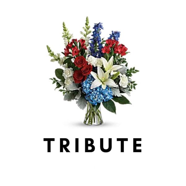 Tribute bouquet with red, white, and blue flowers in a glass vase