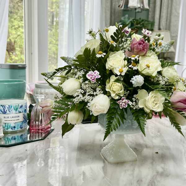 White and pink floral arrangement in a pedestal vase