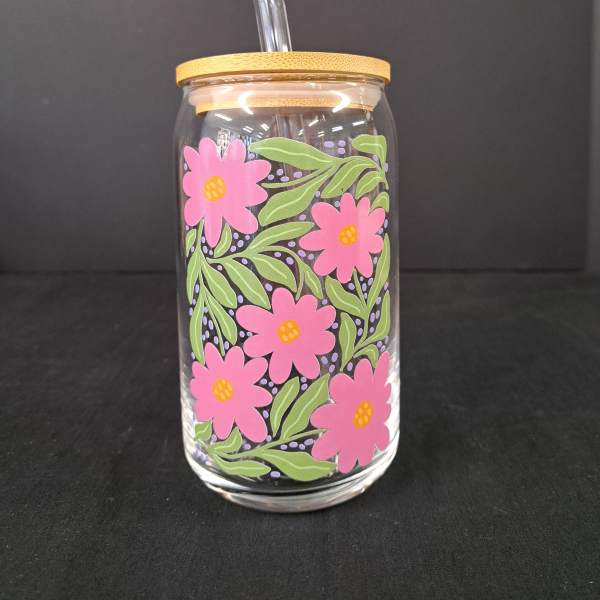 Glass tumbler with pink flower print and a clear straw