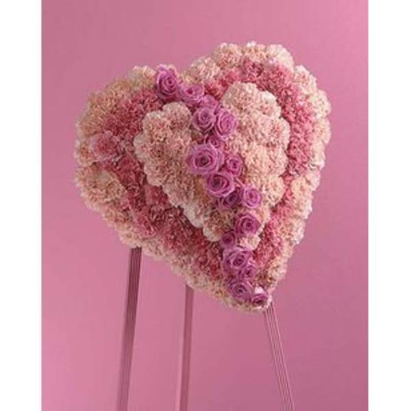 Heart-shaped pink floral arrangement on a stand