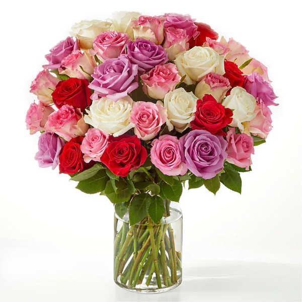 Bouquet of pink, red, and white roses in a clear glass vase