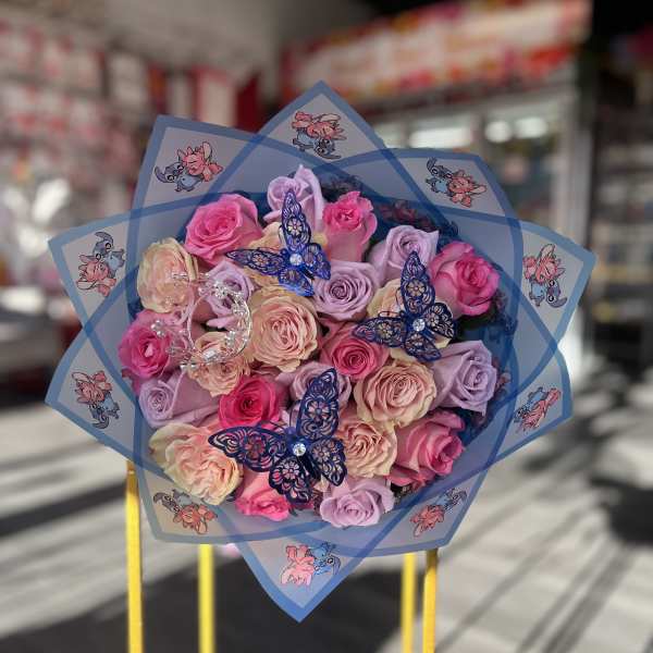Bouquet of pink and lavender roses wrapped in blue paper with butterfly decorations