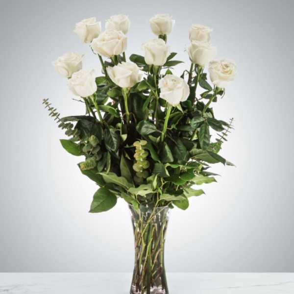 White roses arranged in a clear glass vase
