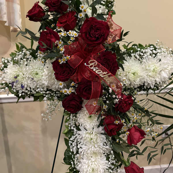 Cross-shaped floral tribute with red roses and white chrysanthemums