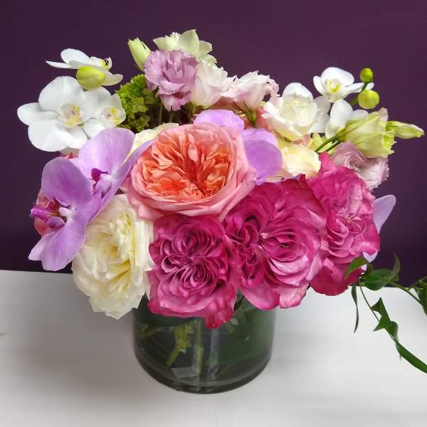 Mixed pink, white, and lavender flowers in a glass vase