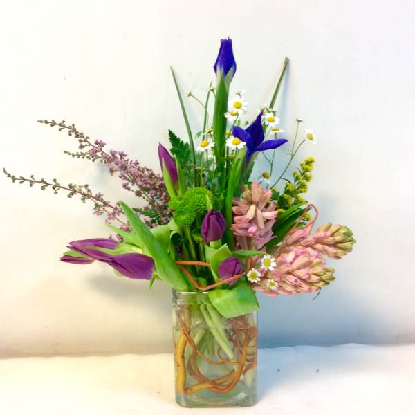 Mixed bouquet in a clear glass vase with purple and pink blooms