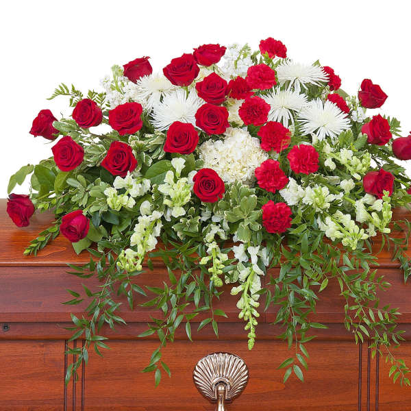 Red roses and white flowers arranged on a casket