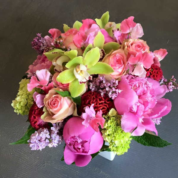 Pink and green mixed bouquet with roses, orchids, peonies, and hydrangea in a white vase