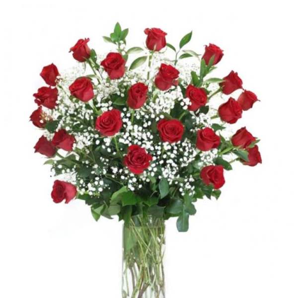 Red roses in a clear glass vase with white filler flowers