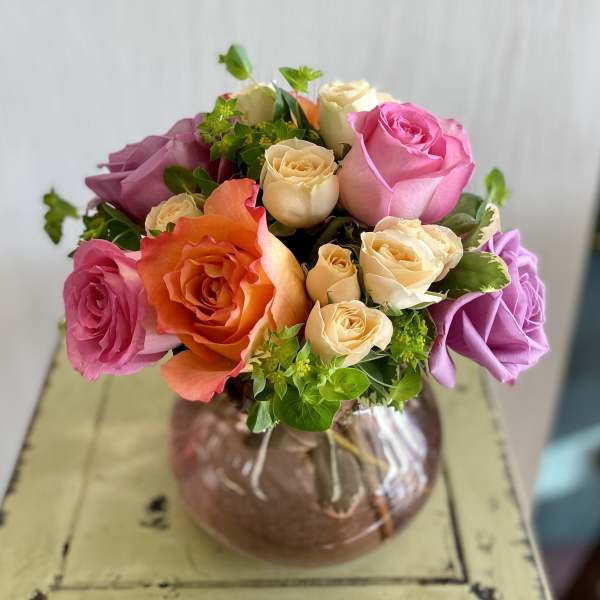 Mixed rose bouquet in a round glass vase
