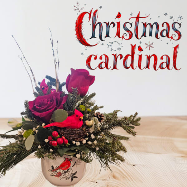 Christmas floral arrangement in a bird-decorated mug with red roses