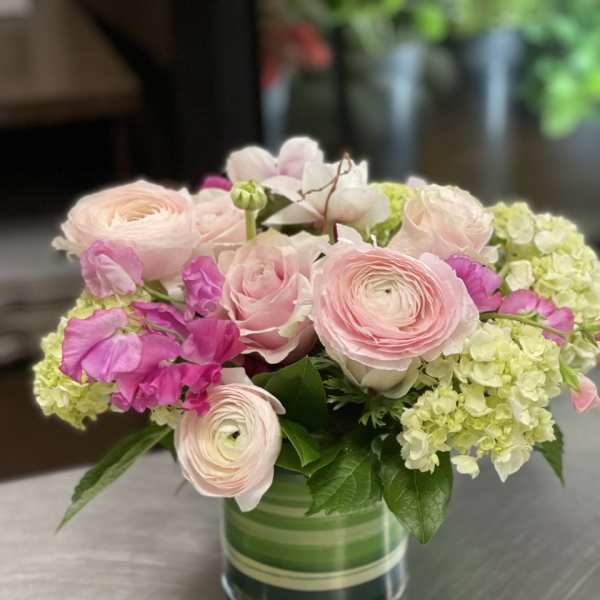 Pink and white flowers arranged in a glass vase