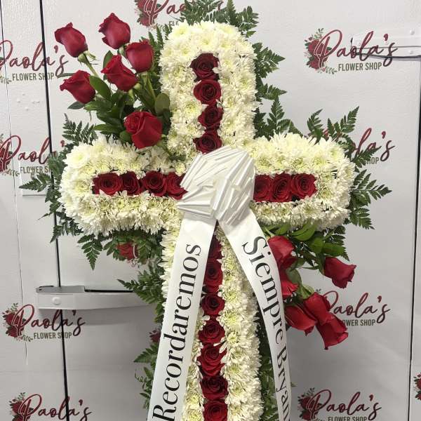Cross-shaped floral funeral tribute with red roses and white chrysanthemums