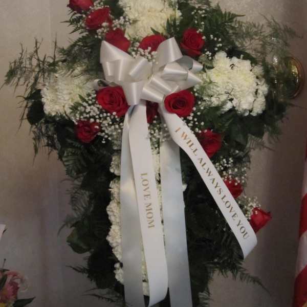 Standing floral spray with red roses, white blooms, and a white ribbon