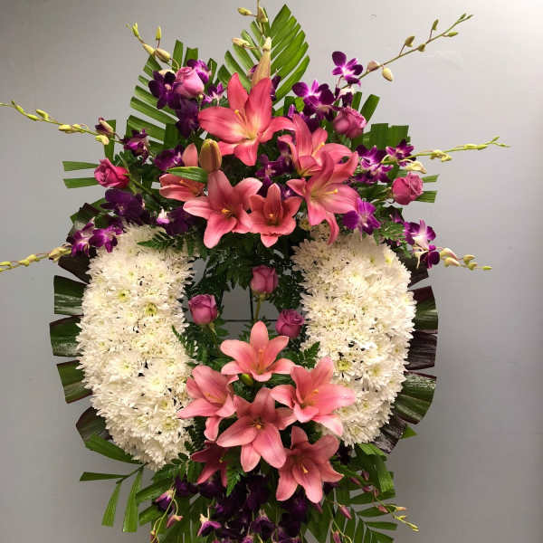 Standing floral spray with pink lilies, purple orchids, and white chrysanthemums