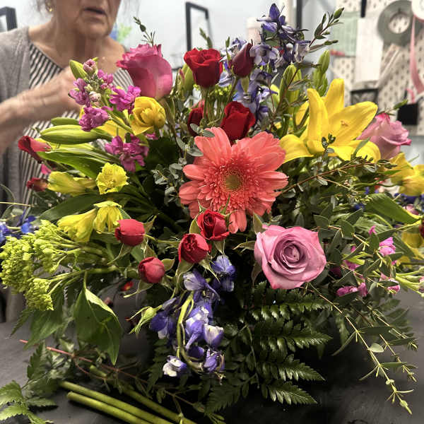 Colorful mixed bouquet with roses, lilies, and a pink gerbera daisy