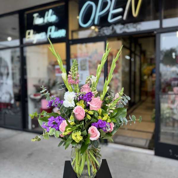 Pink and purple flower arrangement in a clear glass vase