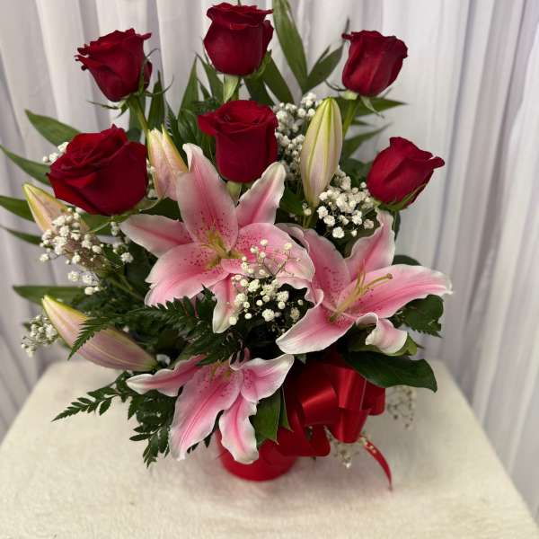 Bouquet of red roses and pink lilies with baby's breath in a red ribbon wrap