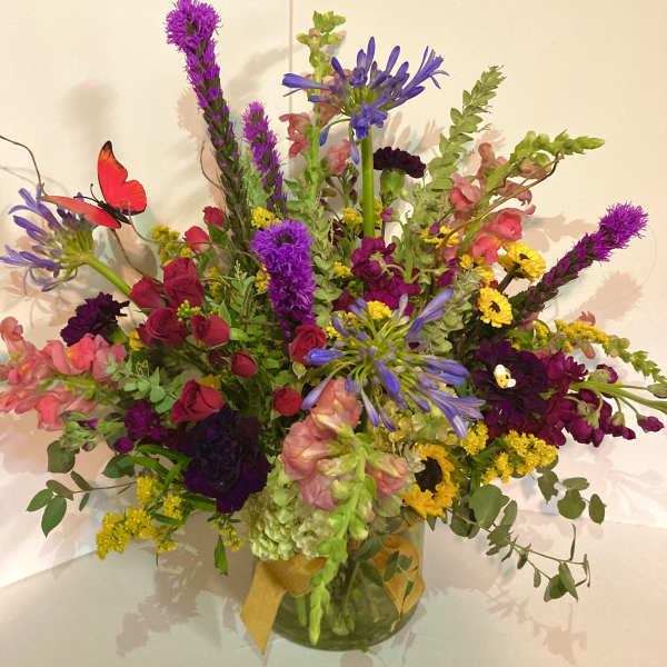 Colorful mixed bouquet in a glass vase with a yellow ribbon